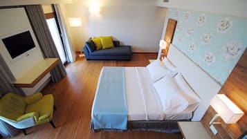 Una habitación de hotel con una cama, un sofá, una silla y un televisor.