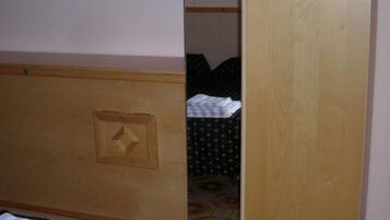 A room with a bed, a wardrobe, and a painting on the wall.