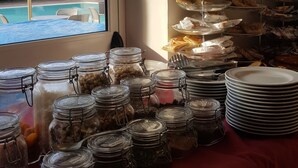 A buffet table with various food items and condiments in glass jars.