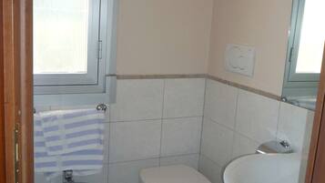 Ein kleines Badezimmer mit Toilette, Bidet und Waschbecken.