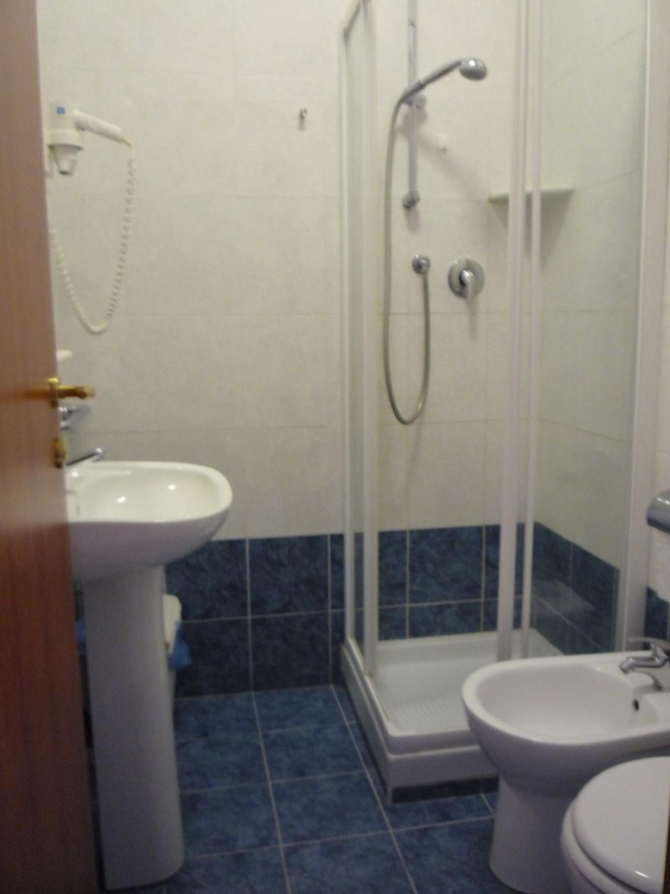 A bathroom with a shower, a sink, and a toilet.