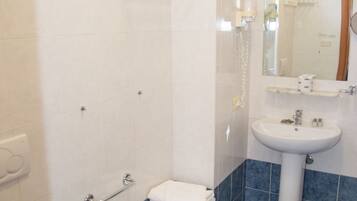 Une salle de bain équipée de toilettes, d’un bidet et d’un lavabo.