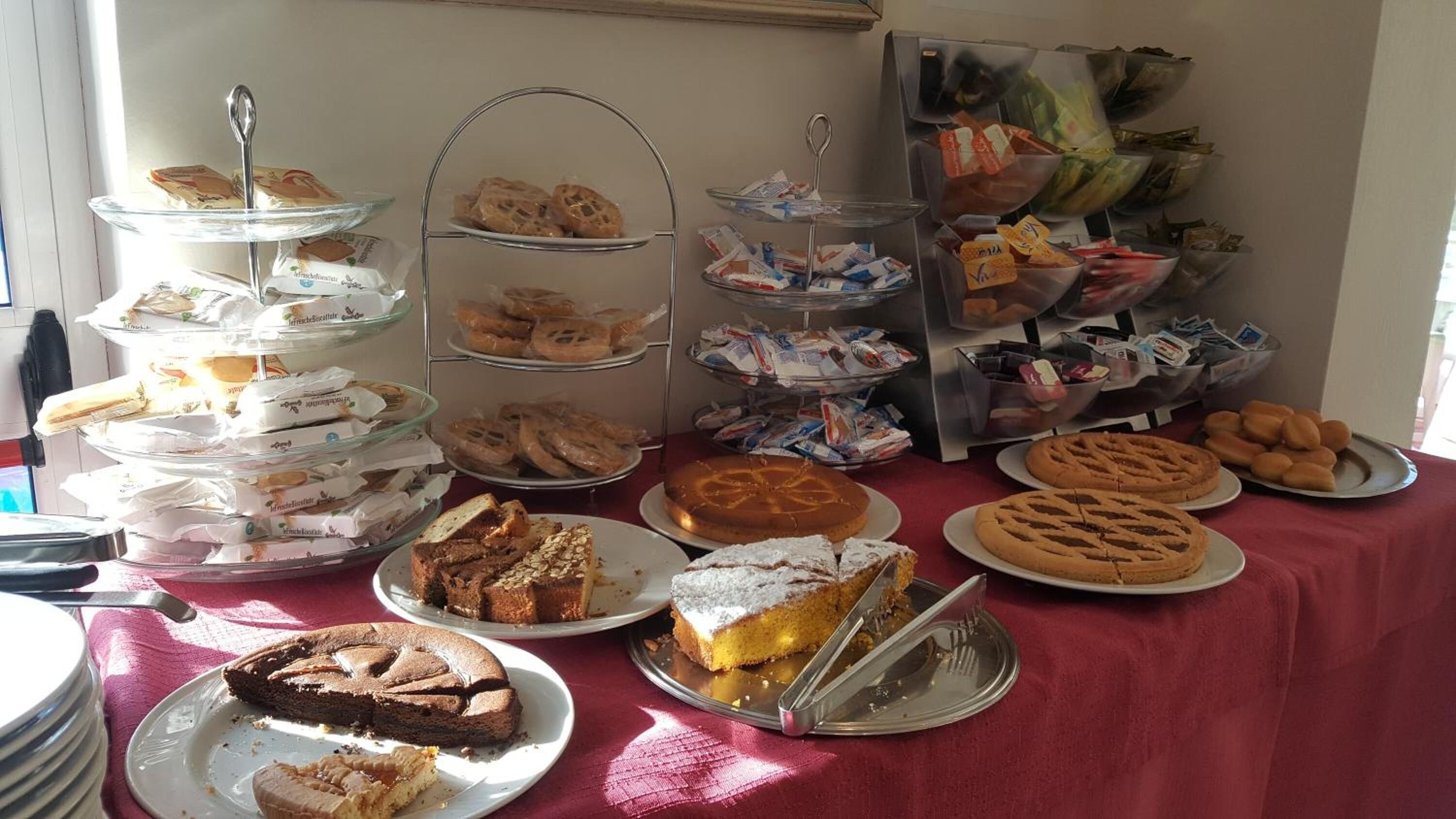 Une table de buffet proposant une variété de viennoiseries, de gâteaux et de sandwichs.