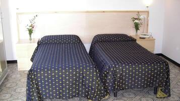 Un letto matrimoniale con testiera, due comodini e una lampada a parete.