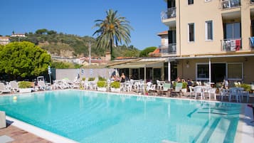 Piscina a l'aire lliure de temporada, para-sols i gandules