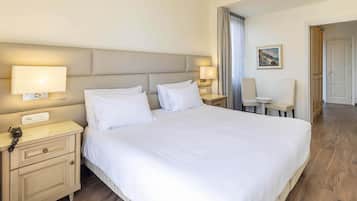 A hotel room with a large bed, bedside tables with lamps, a telephone, and a chair.