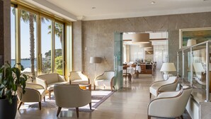A spacious lobby with a view of the sea, modern furniture, and a glass partition separating the dining area. - B&B Hotel Diano Marina Palace (Diano Marina)