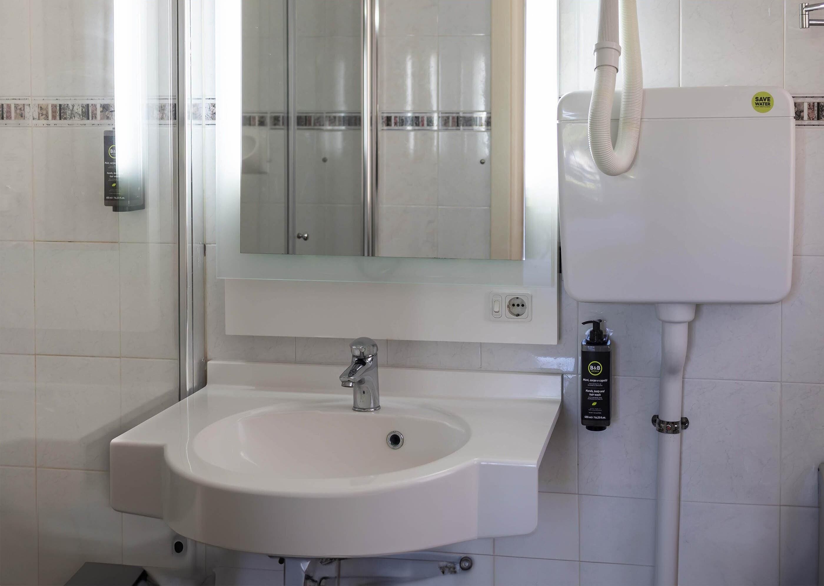 Een badkamer met een witte wastafel, een spiegel en een toilet.