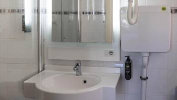 Een badkamer met een witte wastafel, een spiegel en een toilet.