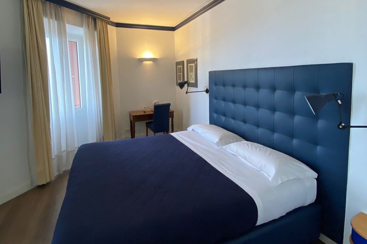 Una habitación de hotel con una cama grande, un escritorio y una silla.
