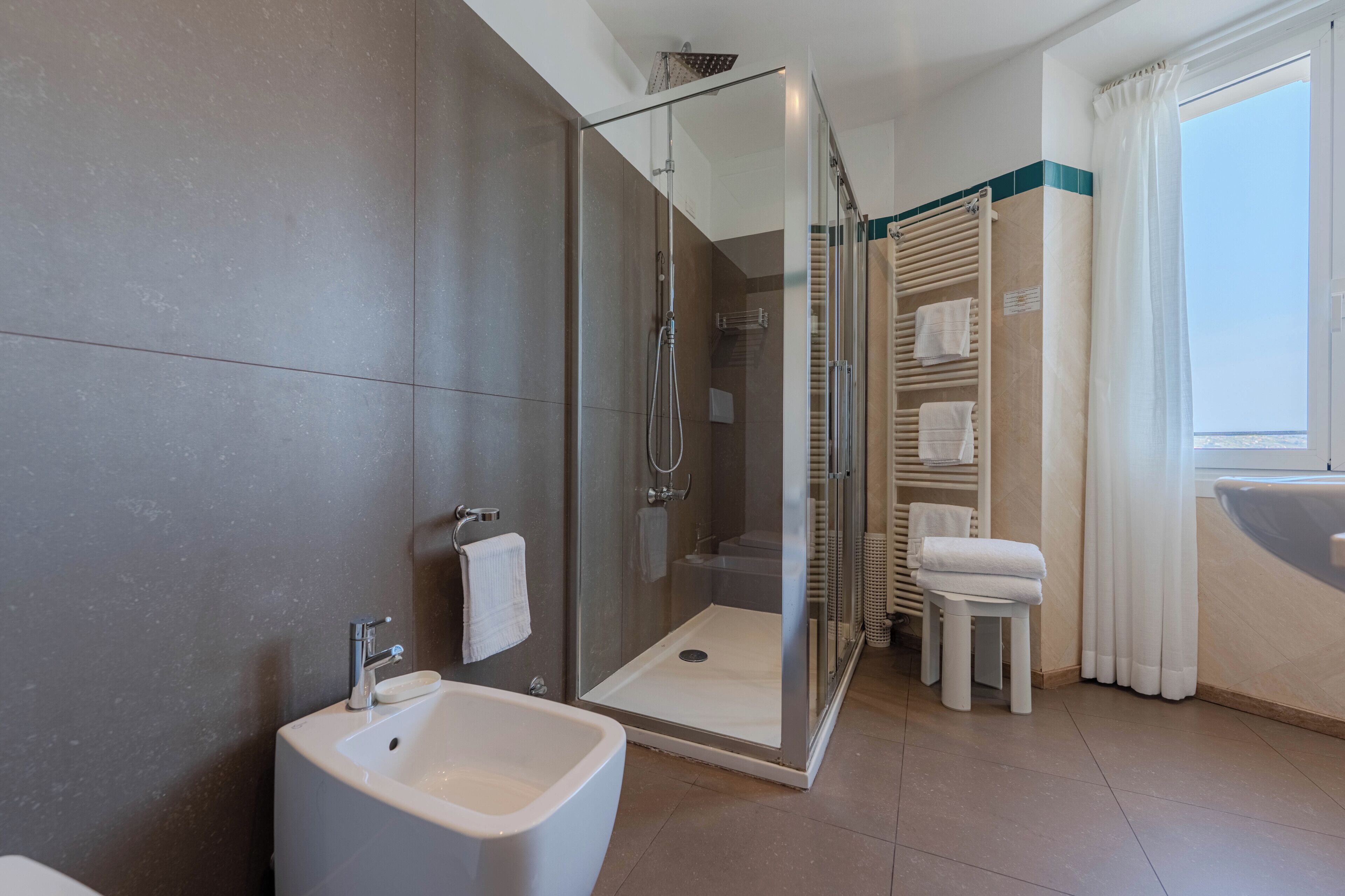 A modern bathroom with a glass-enclosed shower, a sink, and a bathtub.