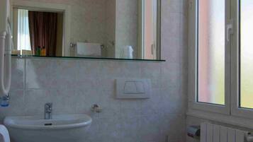 Un baño con lavamanos, inodoro y bañera.