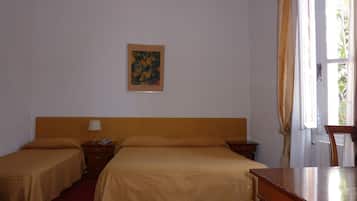Habitación de hotel con dos camas, cabecero de madera, mesita de noche con lámpara, un cuadro en la pared y una ventana con cortinas.