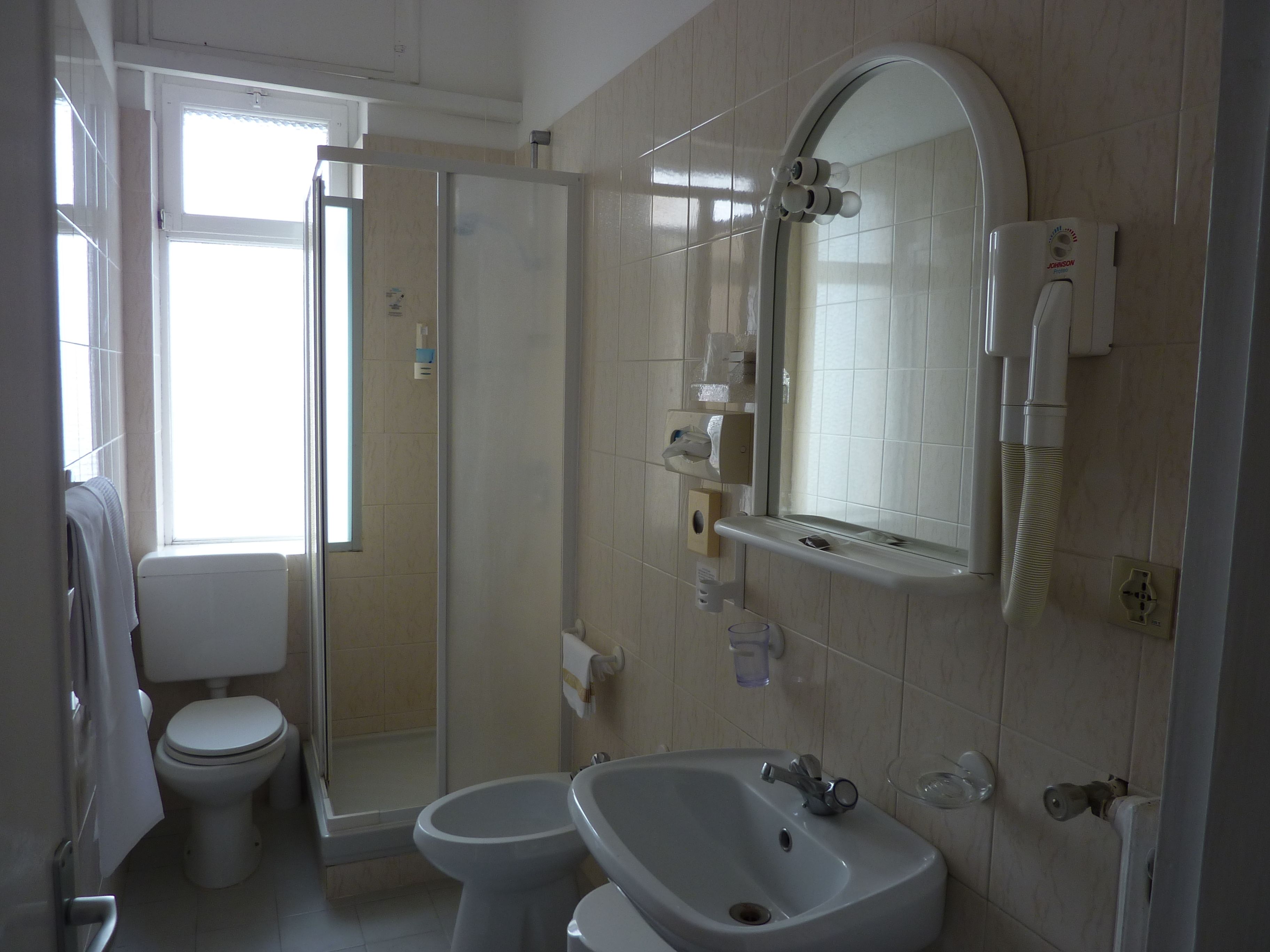 Un bagno con WC, bidet e zona doccia.