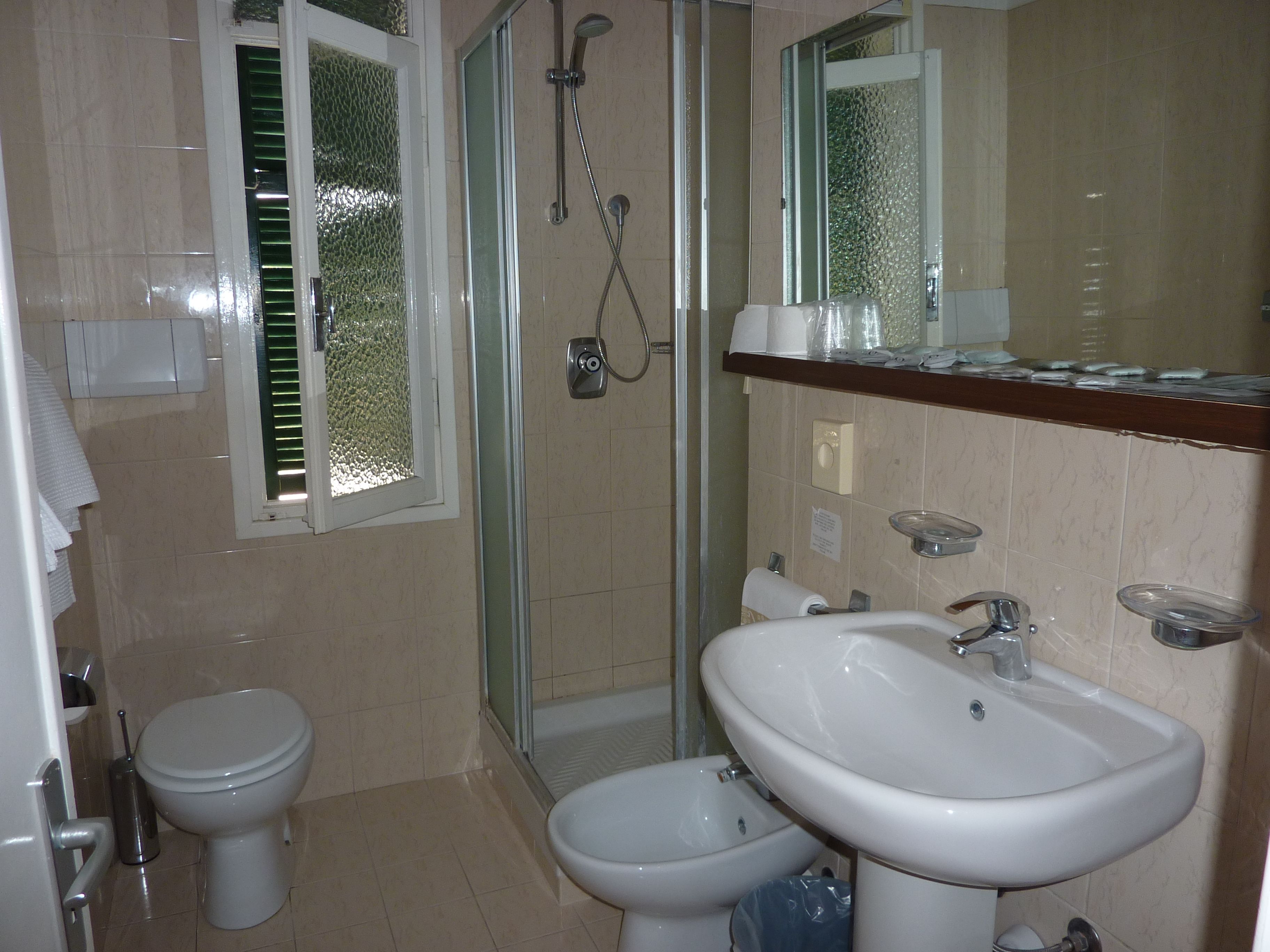 Ein Badezimmer mit Toilette, Bidet, Dusche und Waschbecken.