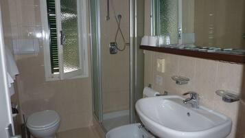 Ein Badezimmer mit Toilette, Bidet, Dusche und Waschbecken.