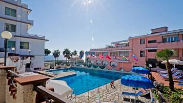 Piscine extérieure, parasols de plage, chaises longues