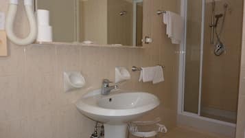 Een badkamer met een wastafel, spiegel, handdoekhouder en douche.