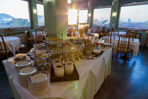 A buffet setup with various food items and serving utensils. - Villa Igea (Diano Marina)
