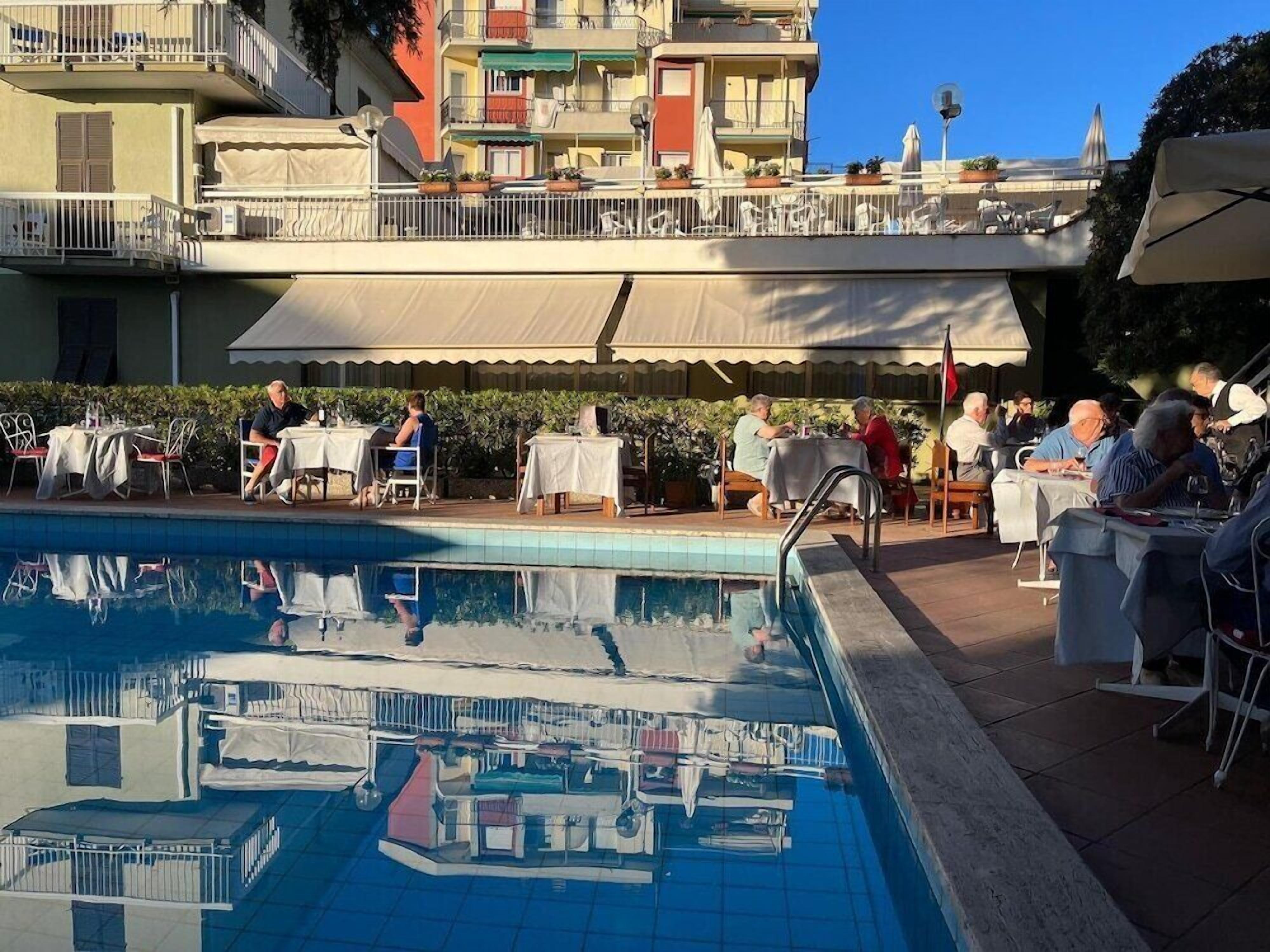 Area piscina con mobili da esterno e vista sugli edifici circostanti.