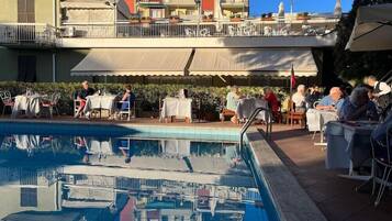 Area piscina con mobili da esterno e vista sugli edifici circostanti.