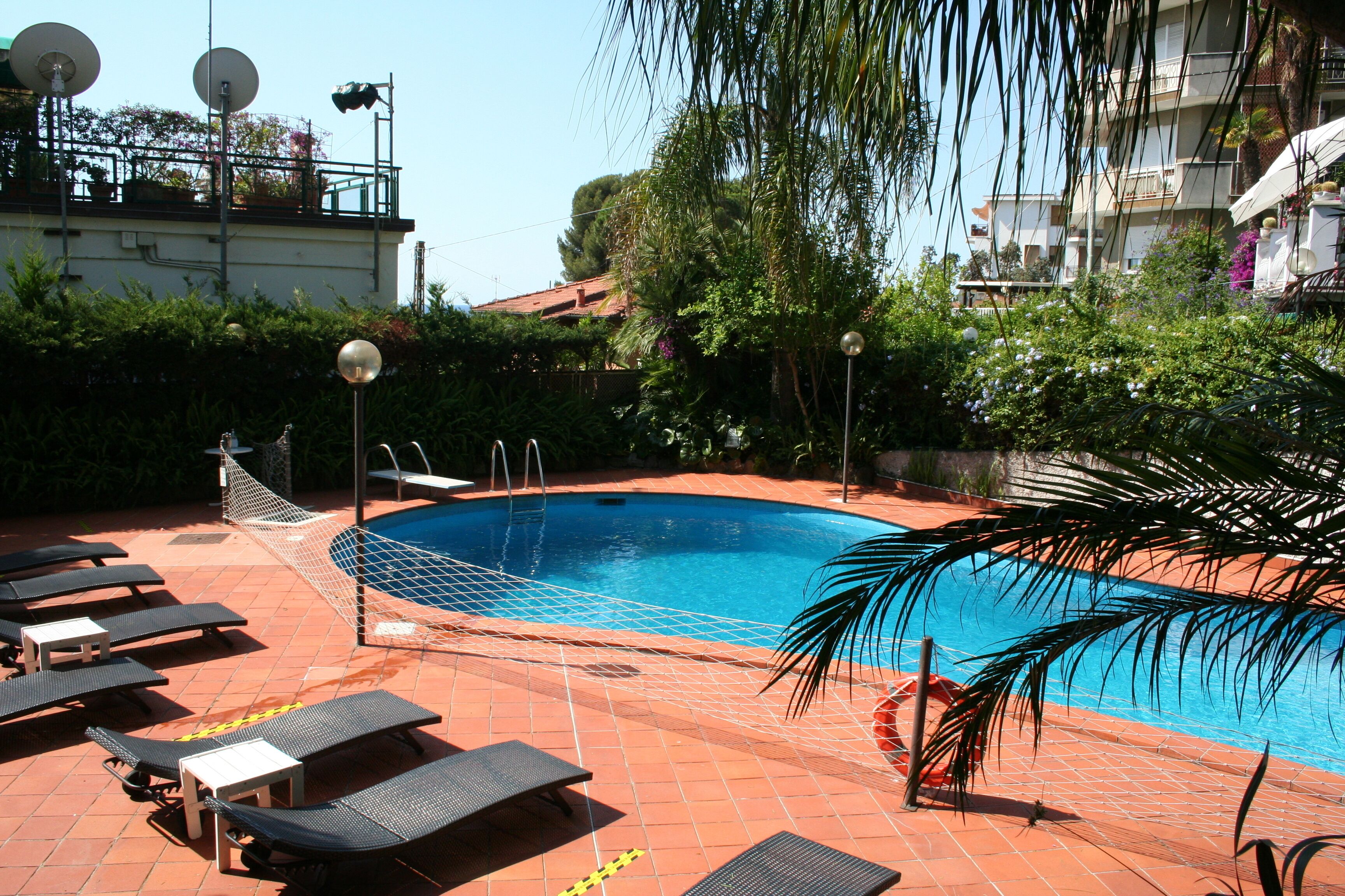 Una piscina al aire libre, sillones reclinables de piscina