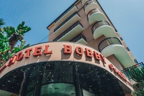 A hotel named "HOTEL BOBBY'S" with a curved facade and balconies. - Hotel Bobby Executive (Sanremo)