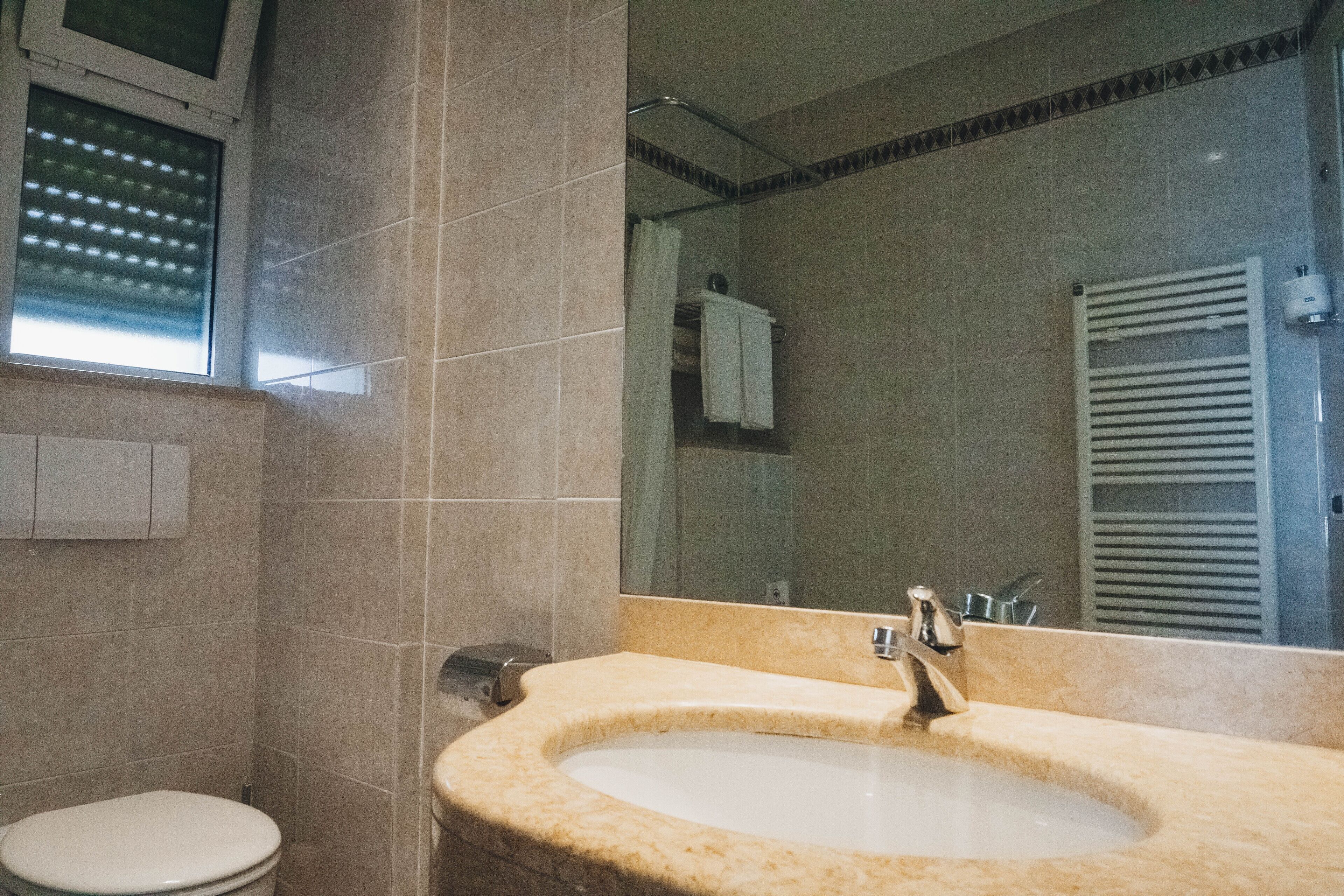 Une salle de bain avec un lavabo, des toilettes et un miroir.
