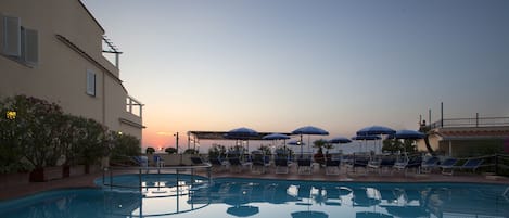 Een seizoensgebonden buitenzwembad, parasols voor strand/zwembad