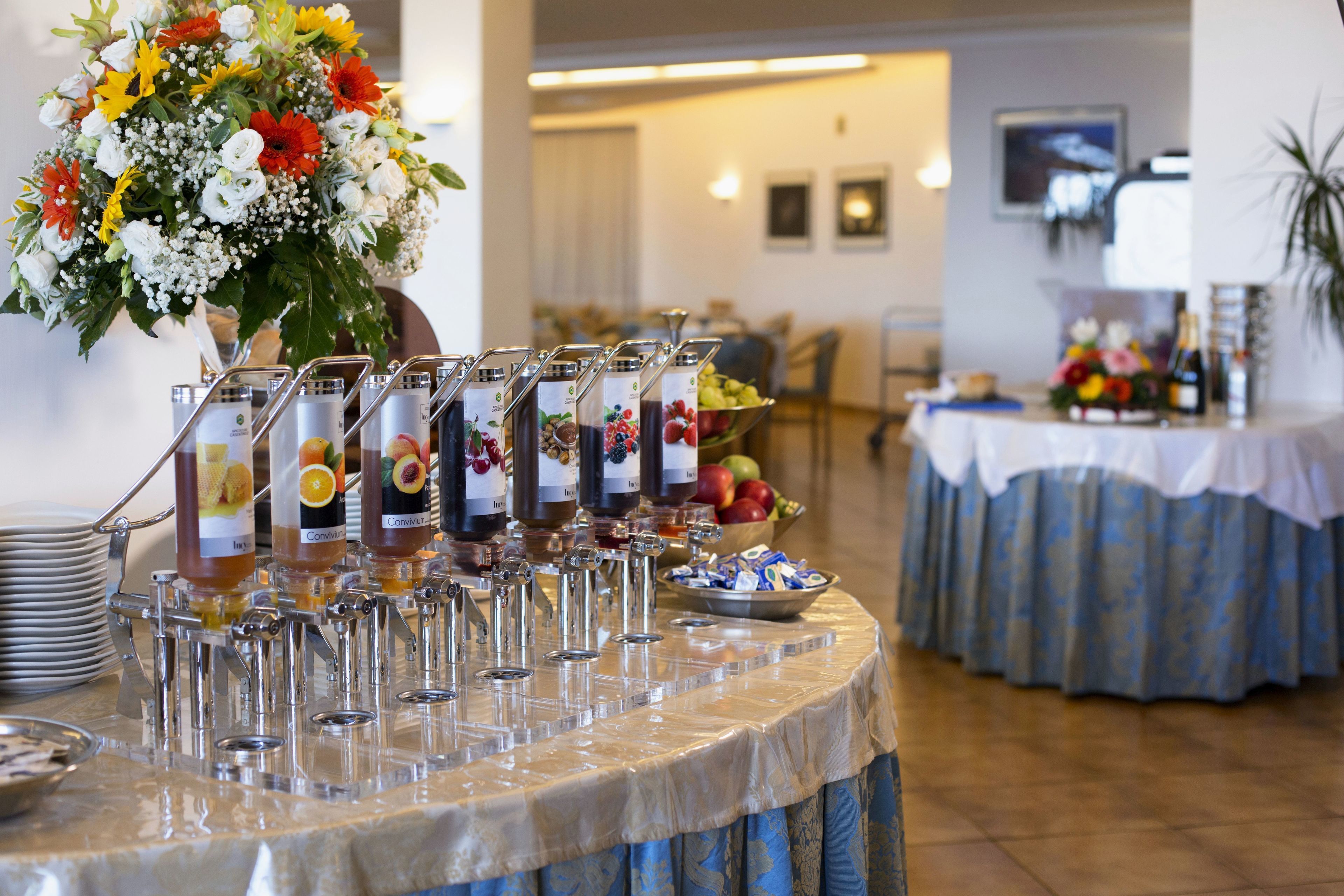 Ein Buffet mit verschiedenen Getränkespendern und einer Obstschale.