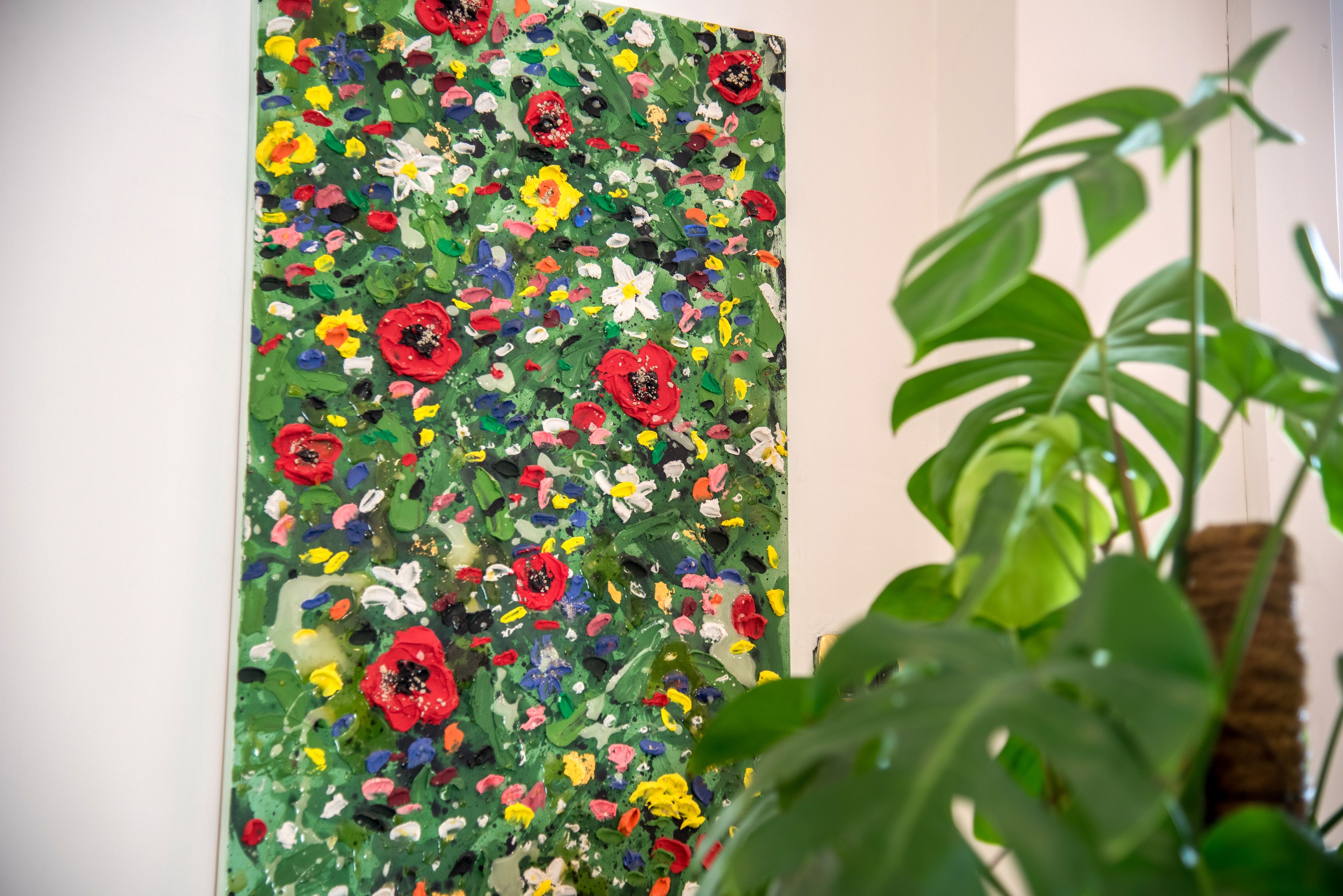 Una pintura abstracta vibrante con una variedad de flores y hojas.