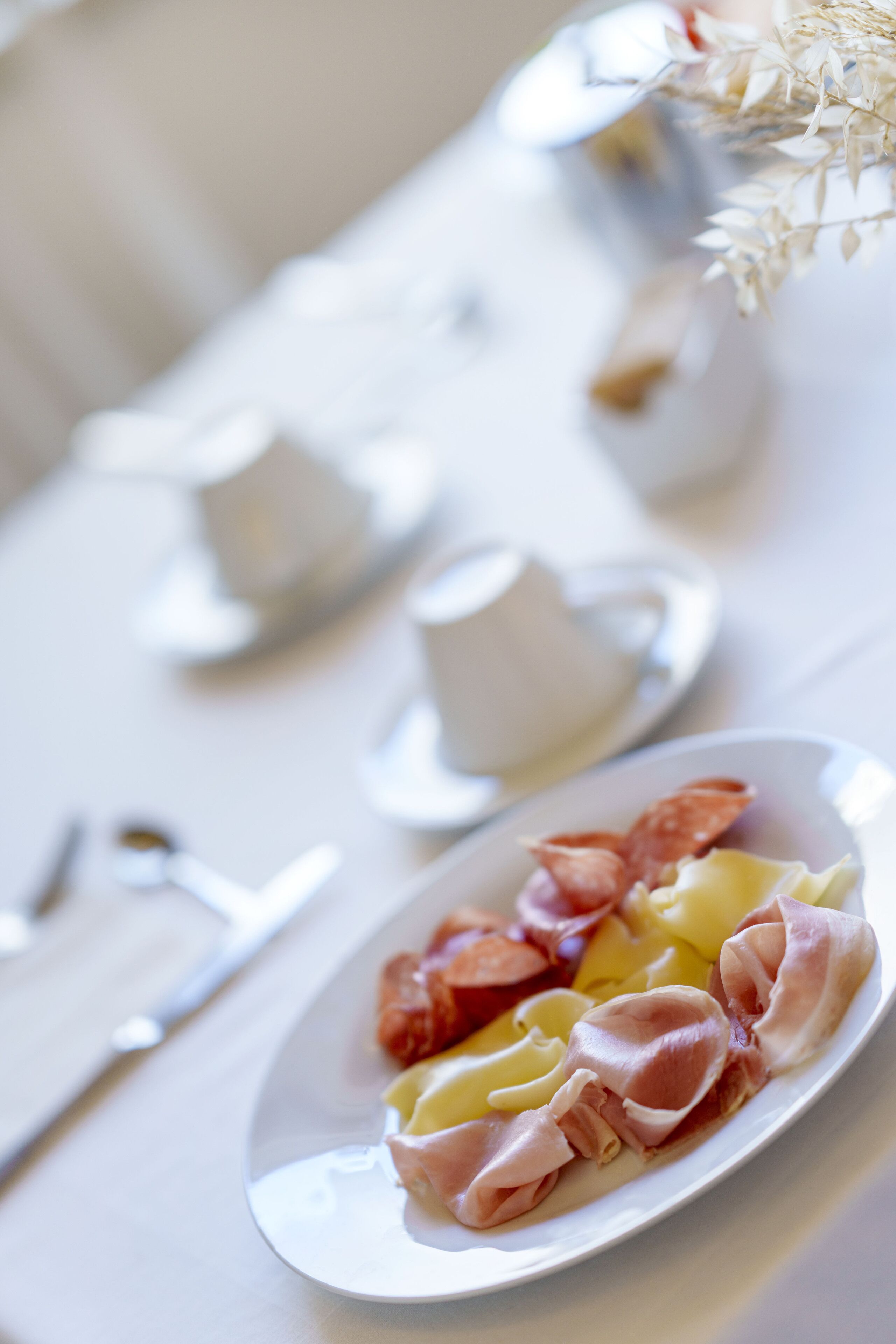 Una mesa de comedor con un plato de comida, una taza y un platillo.