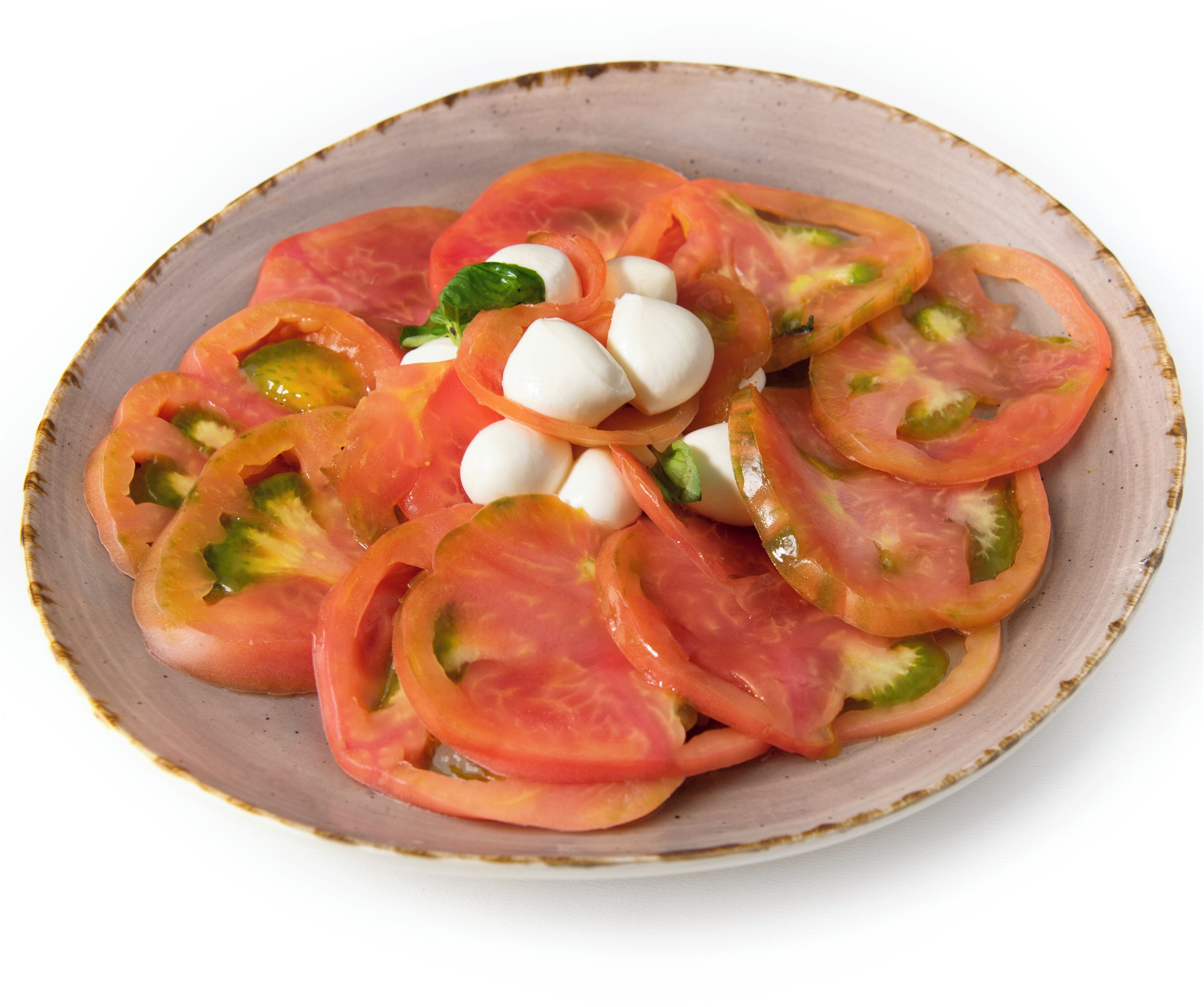 A plate of tomato salad with mozzarella balls and basil leaves.