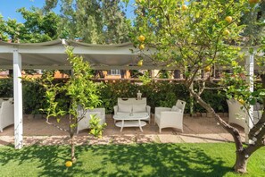 A covered outdoor seating area with wicker furniture and a pergola overhead. - Hotel Capri - Adult Only (Sorrento)