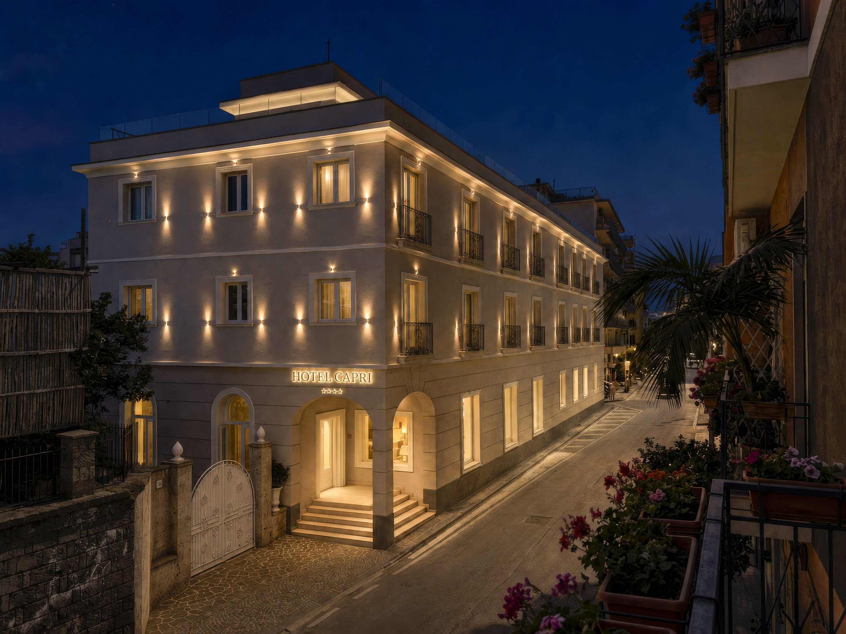 A hotel with a modern facade, multiple balconies, and a well-lit entrance.