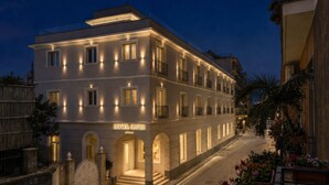 A hotel with a modern facade, multiple balconies, and a well-lit entrance. - Hotel Capri - Adult Only (Sorrento)