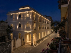 A hotel with a modern facade, multiple balconies, and a well-lit entrance. - Hotel Capri - Adult Only (Sorrento)