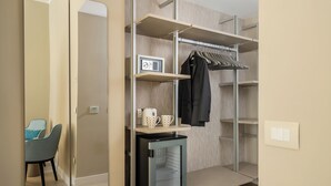 A compact room with a built-in mini-fridge, a coffee maker, and a clothing rack. - Hotel Capri - Adult Only (Sorrento)