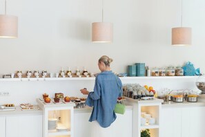 A person in a blue shirt browsing a bakery counter with various baked goods and jars. - Hotel Capri - Adult Only (Sorrento)
