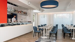 Restaurante moderno com área de bar, disposição de mesas e um grande janelão com cortinas.