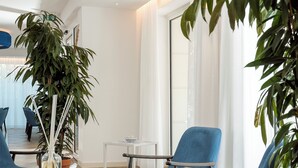 Uma sala de estar moderna com um sofá azul, uma mesa de centro e uma planta em vaso.