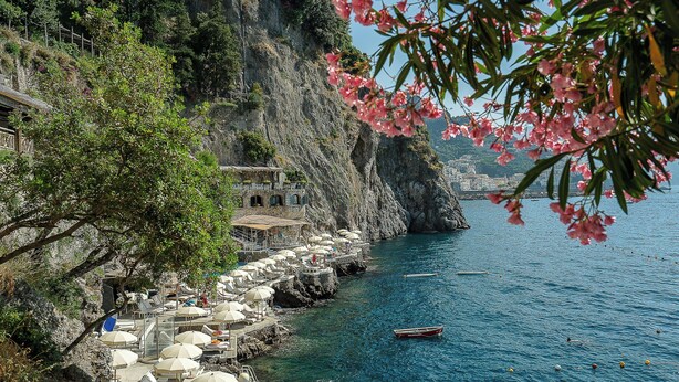 Un hotel frente al mar con terraza y vistas al océano.