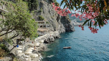 على الشاطئ، كراسي للتشمس، مظلات الشاطئ، مناشف للشاطئ