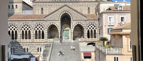 Vista de un edificio histórico con una cúpula central y ventanas arqueadas, a través de un arco.