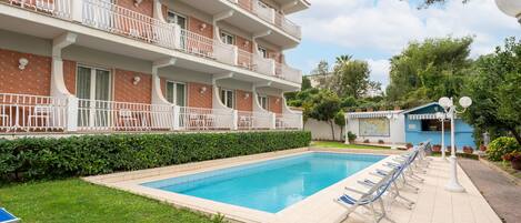 Piscine extérieure en saison, chaises longues