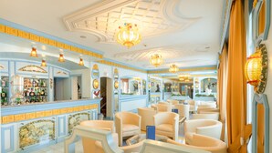 Un hall d’hôtel comprenant un bar, des espaces pour s’asseoir et des éléments décoratifs.