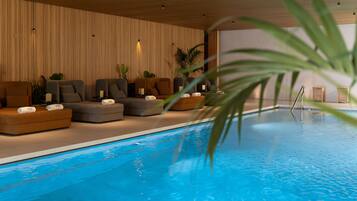 Un área interior de piscina moderna con asientos y plantas.
