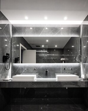 Un baño moderno con dos lavamanos, un espejo grande y una zona de ducha.