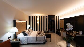 Una habitación de hotel con cama, mesita de noche, lámpara y escritorio con silla.
