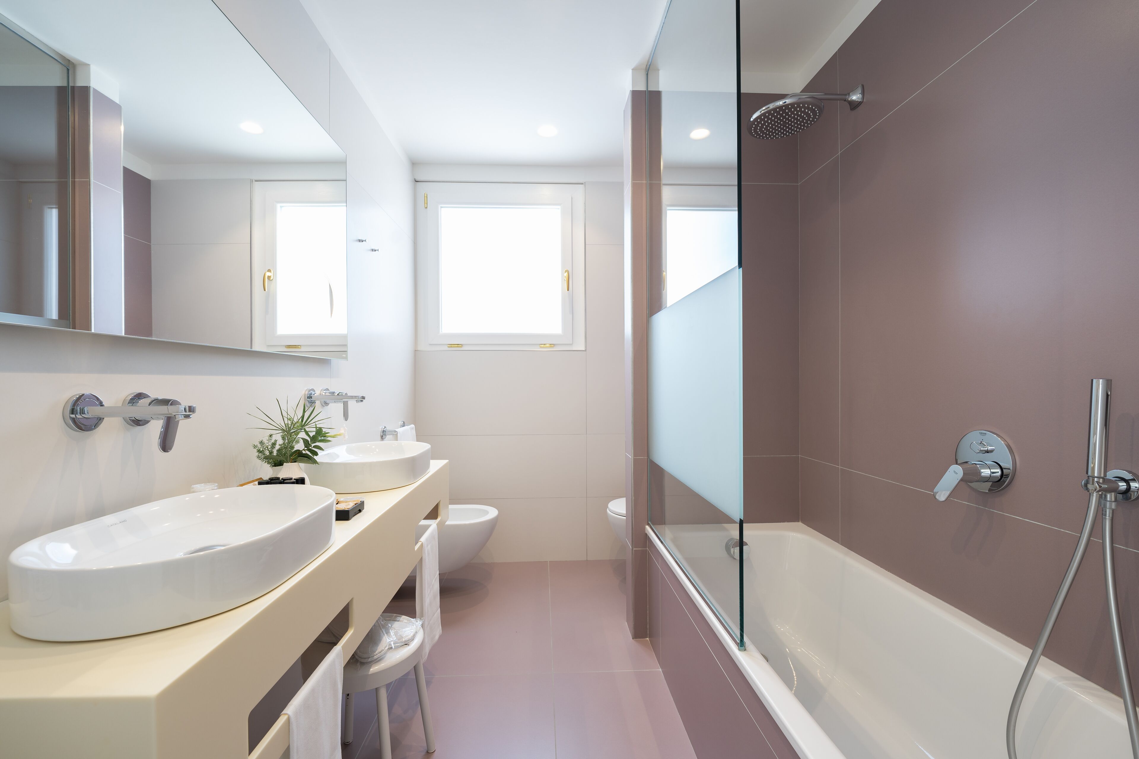 A modern bathroom with a large oval sink, a glass-enclosed shower, and a toilet.